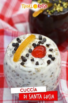 a close up of a dessert in a glass on a checkered table cloth with the words cuccia di santa lucia