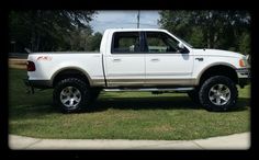 a white pick up truck parked in the grass