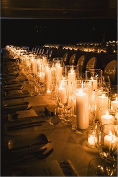 a long table is set with candles and place settings for dinner guests to sit at