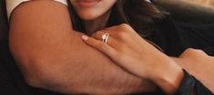 a close up of a woman wearing a ring on her left hand and holding onto the arm of a chair