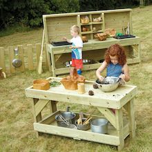 a woman and her child are cooking outside