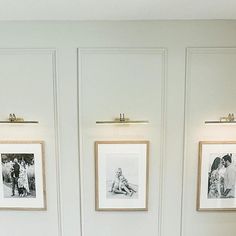 three framed pictures hang on the wall above a toilet in a bathroom with white walls