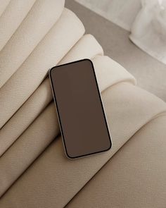 a cell phone laying on the back of a couch