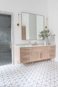 a bathroom with a sink, mirror and tiled floor