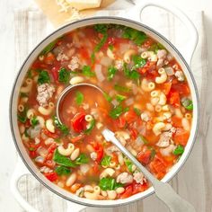 a pot filled with pasta and meat soup