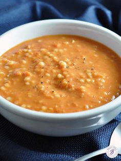 a white bowl filled with soup on top of a blue cloth