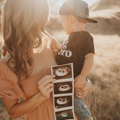 a woman holding a child in her arms with pictures on the front and back of it