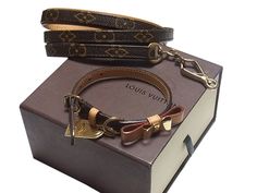 the louis vuitton bracelet is sitting on top of a box with a keychain