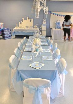 a table set up for a baby shower party with blue and white decorations on it