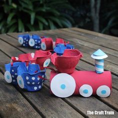 some paper cups are sitting on a table with a toy train in front of them