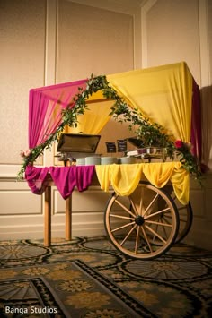 an old fashioned wagon decorated with flowers and greenery for a wedding or party decoration