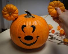 a pumpkin with a mickey mouse face painted on it