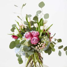 a vase filled with lots of flowers and greenery