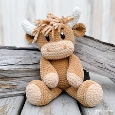 a small stuffed cow sitting on top of a wooden table