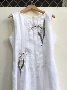 ❤ The white hand embroidered linen dress is very soft, skin friendly, breezy and comfortable.  ❤ Item description: - A lovely dress with embroidered Lily of the valley flowers motifs. - Material: linen, embroidery threads. - Environmentally friendly. - This dress is very useful, go with any outfit, that can be used to go to school, go out, go shopping.    It is a perfect gift for yourself or your beloved.  ❤ Care instructions:       The best way to wash embroidery cloth is to put it in soapy water (with a mild detergent and cold water at 86 ºF/30oС) for 20 minutes. Try to not wash the item with other clothing that might cause damage, such as zippers, buttons or different colors. You wash it by hand, and if you have dirty patches on your garment, you can gently rub them, it's best not to ru Linen Wedding Dress With Floral Embroidery, Sleeveless Linen Wedding Dress, Fitted Linen Embroidered Summer Dress, Fitted Linen Embroidered Dress For Summer, Fitted Embroidered Linen Dress For Summer, Spring Garden Party Linen Embroidered Dress, Fitted Linen Dress With Floral Embroidery For Summer, Summer Embroidered Linen Dress For Garden Party, Summer Linen Embroidered Dress For Garden Party