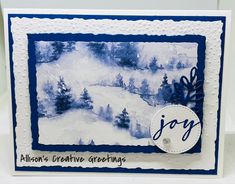 a handmade christmas card with blue and white watercolors on it, featuring an image of a snowy landscape