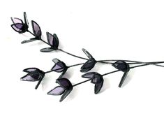 three purple flowers with black stems on a white background