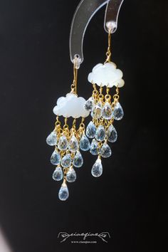 ---- Welcome to CiaoQiao Shop ----- Embrace the serene beauty of a gentle rain with these captivating Raincloud Charm Earrings. Each earring showcases a cloud crafted from white moonstone, from which a collection of sparkling crystal raindrops gracefully descend. Perfect for bringing a whimsical touch to your ensemble, they embody the peaceful moments of a rain shower. Length: 2 3/4″ | 6.9cm, width: 3/4" | 1.9cm What does "14k gold filled" mean? "Gold-filled" is a USA industry standard that lega White Drop Chandelier Earrings For Anniversary, White Drop Chandelier Earrings, White Crystal Drop Earrings For Anniversary, Raining Diamonds, White Teardrop Crystal Earrings With Gemstone, White Gemstone Drop Earrings, White Gemstone Crystal Dangle Earrings, Gemstone Drop Chandelier Earrings, White Teardrop Gemstone Crystal Earrings