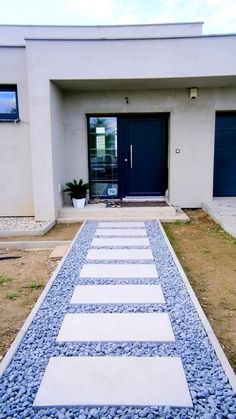 a white and blue walkway in front of a house with two doors on each side