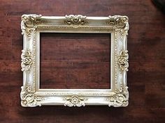 an old white frame on a wooden table