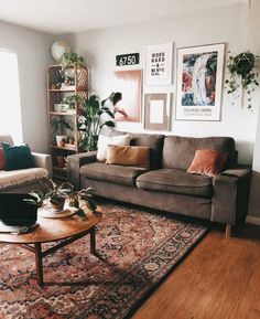 a living room with two couches, a coffee table and some pictures on the wall