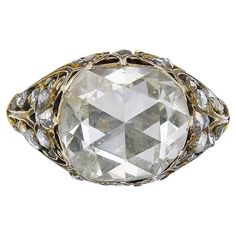 an old cut diamond ring with filigrees on the sides and two tone gold accents