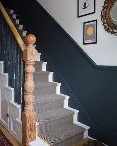 there is a stair case on the wall next to the bannister and mirror