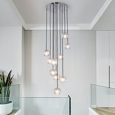 a bathroom with white walls and flooring has a chandelier hanging from the ceiling