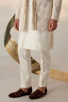 Ivory full sleeves bandhgala with all over abstract embroidery with tone on tone, champagne, old rose, and gold threads. Paired with matching slim fit tapered trouser.
Components: 2
Pattern: Embroidery
Type Of Work: Ditsy Floral
Neckline: Band
Sleeve Type: Long
Fabric: Linen Silk
Color: Ivory
Other Details: 
Twisted borders at the front
Note: The inner kurta worn by the model is not for sale
Occasion: Cocktail and Reception, Wedding - Aza Fashions Luxury White Bandhgala With Gota Work, Luxury Beige Chikankari Embroidered Bandhgala, Manpreet Toor, Blouse Yoke, Abstract Embroidery, Dhoti Pants, Haldi Ceremony, Old Rose, Tapered Trousers