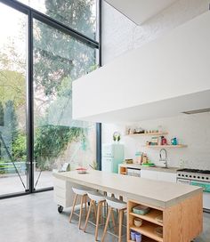 an open kitchen and dining area with large windows