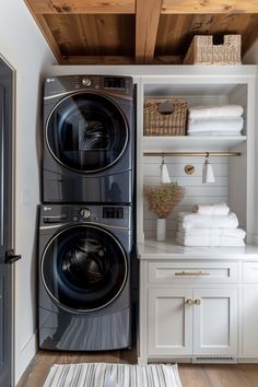 a washer and dryer in a white laundry room with wood ceilinging, open shelving