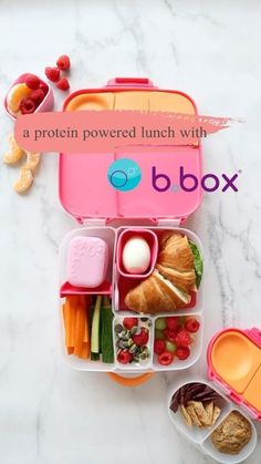 a pink lunch box filled with food on top of a white countertop next to other containers