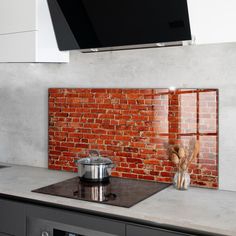 a stove top oven sitting next to a brick wall