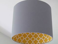 a gray and yellow lamp shade hanging from the ceiling