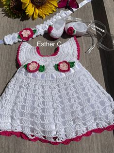 a crocheted baby dress and booties with flowers