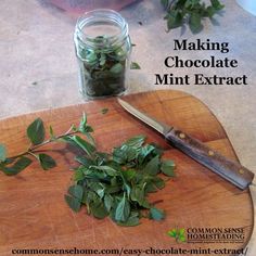 a wooden cutting board topped with green leaves next to a jar of chocolate mints