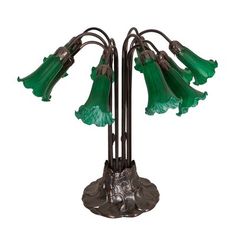 a green glass flower lamp on a metal stand with four lights attached to it's sides