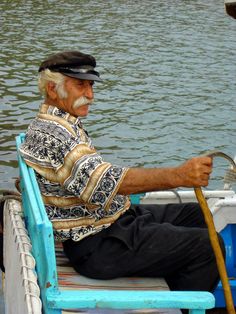 an old man sitting in a boat on the water