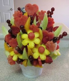 a vase filled with lots of fruit on top of a counter