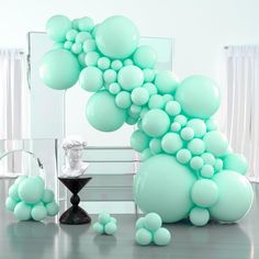 balloons are floating in the air next to a table with a busturine on it