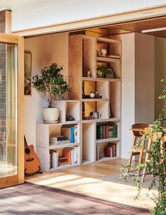 a living room filled with lots of furniture and bookshelves next to a window