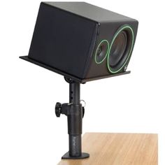 a black speaker sitting on top of a wooden table