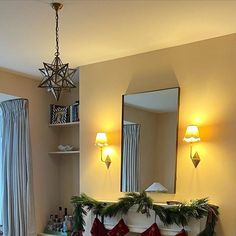 a bathroom decorated for christmas with stockings on the counter and lights hanging from the ceiling