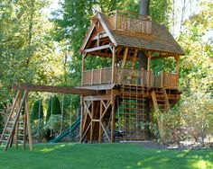 a tree house built into the side of a green field