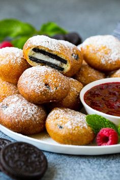 a plate full of pastries with raspberries and oreo cookies on the side