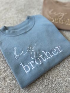 The perfect touch to reveal your new arrival to a sibling 🫶🏼 Perfect to get the older siblings excited about their new arrival!  When I was pregnant with my second son, my son loved wearing his big brother tshirt proudly and was so excited when he read it himself to find out about his new baby sibling 🤍 Can also be made to say 'big sister' aswell as 'little brother' or 'little sister' for the baby to match 🤍 (Please see other listings in my shop as I can't have them all under one item!) 100% Upgraded To Big Brother, 2 Older Brothers And A Sister, Big Brother Embroidered Shirt, Blue T-shirt For Gender Reveal On Father's Day, Blue T-shirt For Father's Day Gender Reveal, Personalized Crew Neck T-shirt For Gender Reveal, Older Sibling Pregnancy Announcement, Big Brother Shirt Announcement, Pregnancy Announcement Surprise