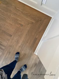 a person standing on the floor in front of a door with their feet propped up