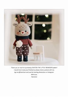 a knitted reindeer doll standing next to a white chair