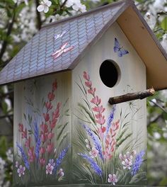 a bird house painted with flowers and butterflies