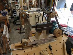 a machine that is sitting on some kind of workbench in a room filled with tools